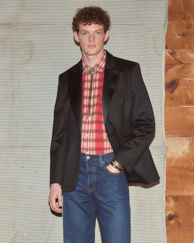 Man wearing suit jacket with dark-wash jeans.