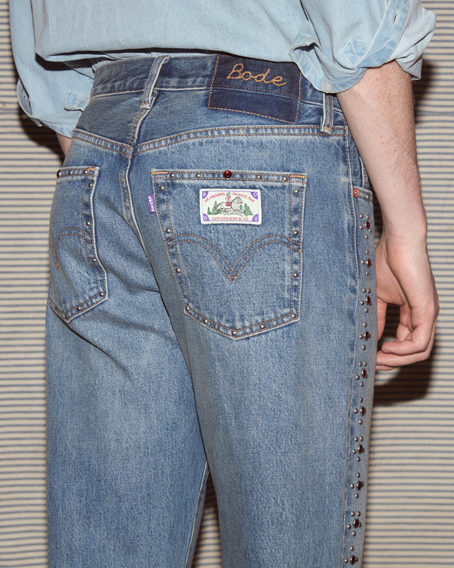 Man wearing light-wash jeans and a chambray shirt.