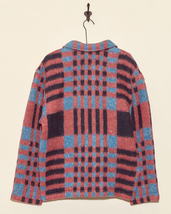 The Berry Crate Jacket - S/M features a unique pink and blue plaid wool design with striking red, blue, and black check patterns, displayed on a wall hook.