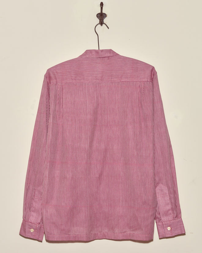 The Berry Creme Stripe Shirt - S/M, a red and white vintage long-sleeve shirt, is displayed from the back on a wall-mounted hook.