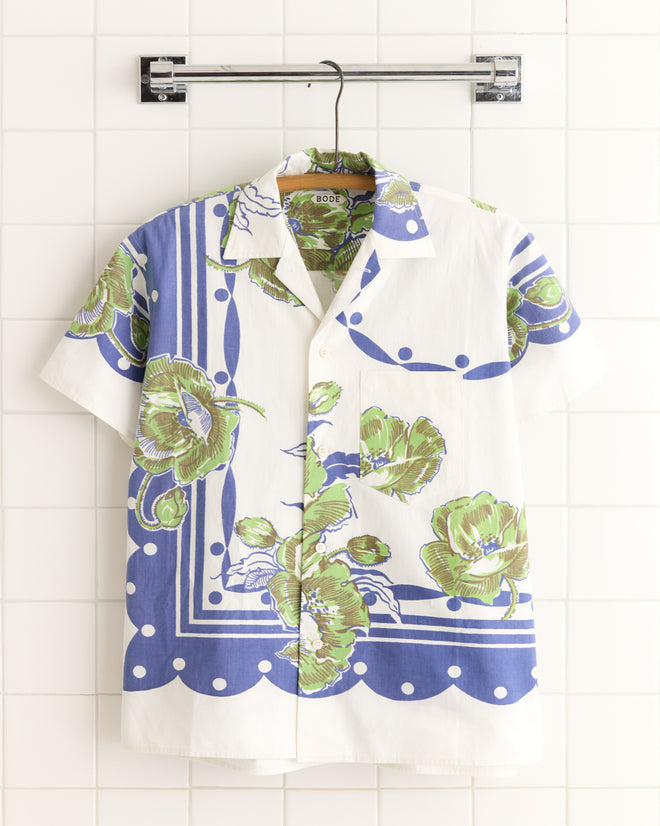 Blueberry Polka Dot Shirt - S/M: a short-sleeve white vintage shirt with blue and green polka dot pattern, hanging on a rack against a tiled wall.