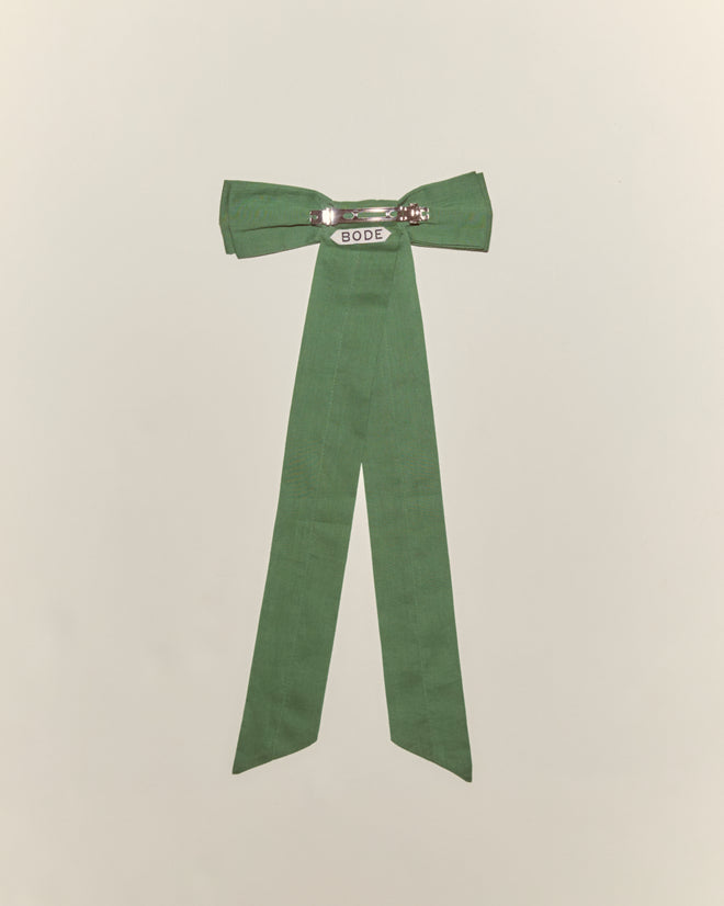 The Bow Barrette - Green features a charming cotton fabric bow with long tails, a metal clasp labeled "BODE," and is ideal for fans of unique hair accessories. Shown on a plain light background.