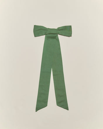 The Bow Barrette - Green is a cotton hair accessory with long tails, ideal for vintage girl’s styles. Shown on a simple light background.