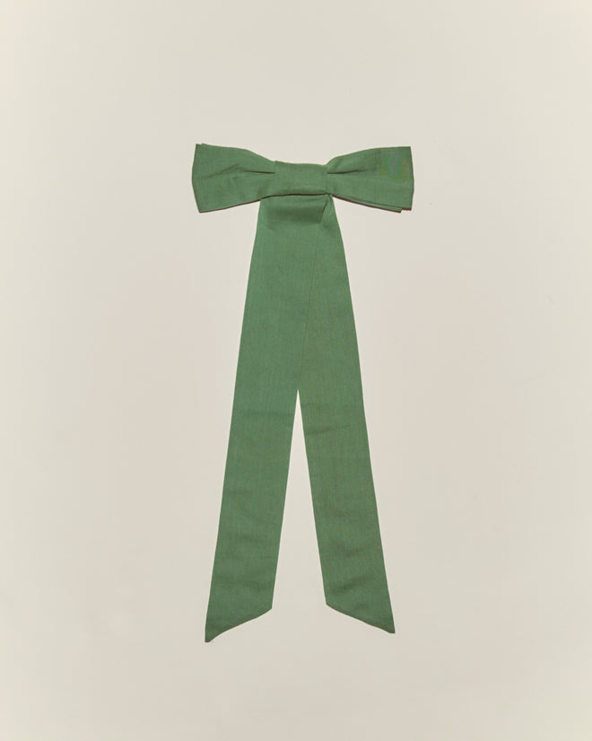 The Bow Barrette - Green is a cotton hair accessory with long tails, ideal for vintage girl’s styles. Shown on a simple light background.