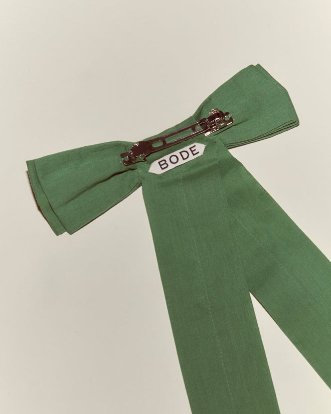 The Bow Barrette - Green features a green fabric bow with a metal pin and "BODE" label on the back, making it a charming vintage-inspired addition to your hair accessory collection. Displayed on a plain surface for clarity.