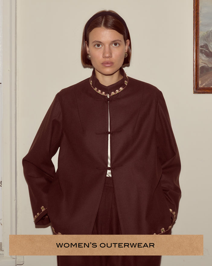 Brown swing jacket with crocheted floral trim around the collar and ornamental frog closures