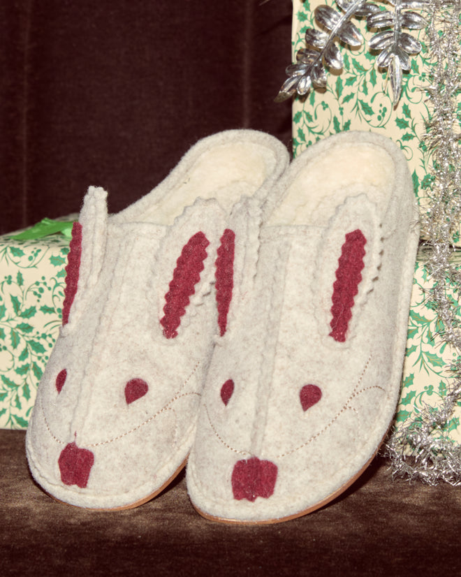 Rabbit Slipper - Cream Red: Cream slippers featuring red bunny faces, ears, and noses, placed next to a green-patterned gift box.