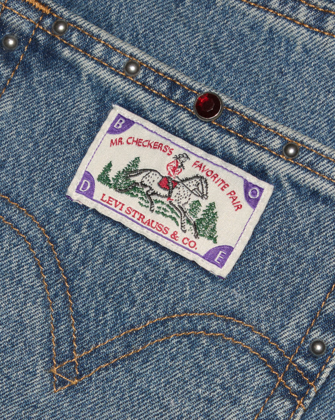 Light-wash jeans with silver studs and red gemstones.