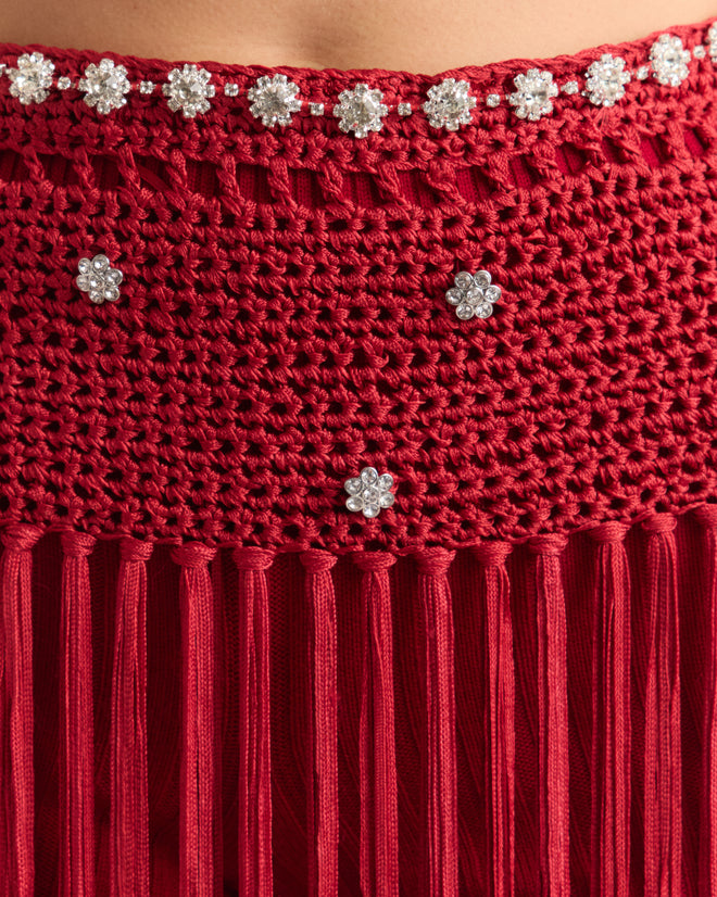 Close-up of the red Calder Fanni Fringe Skirt, featuring flower-shaped rhinestone details and hanging fringes, evoking the vibrant textures of Calder’s Circus at the Whitney Museum of American Art.