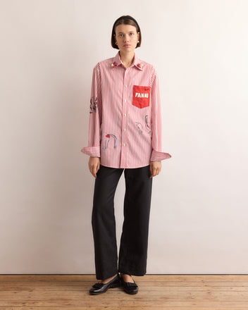 Woman in a Calder Painted Cirque Long Sleeve Shirt, black pants, and black shoes stands against a plain background—adding Alexander Calder-inspired flair and handmade New York style to her look.