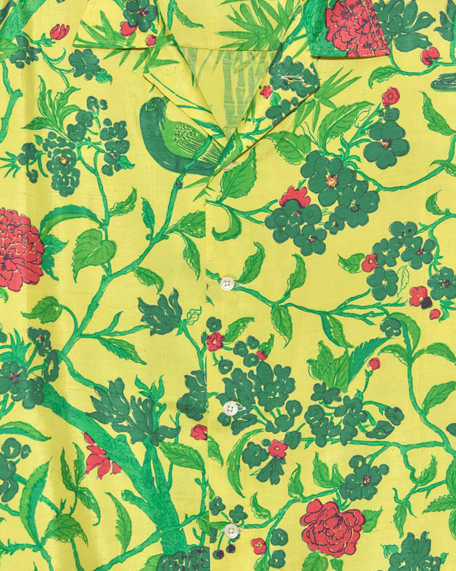 The Chartreuse Jungle Shirt - M/L showcases a yellow base with green and red floral and bird prints, finished with classic white buttons. A true one-of-a-kind piece for unique style seekers.