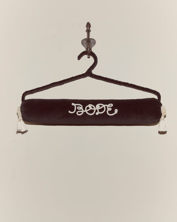 The Cloakroom Hanger - Black features “BOOF” embroidered in white on plush black velvet with a velvet ribbon, elegantly displayed on a wall hook.