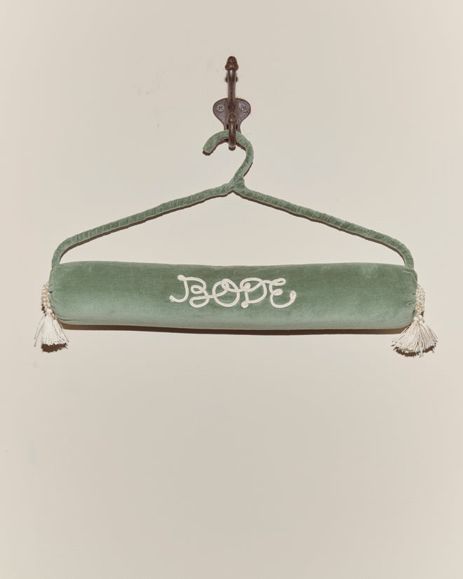 A Cloakroom Hanger - Teal, featuring "HOPE" embroidered in white and finished with tassels at each end, adds a touch of charm when displayed on a wall hook.