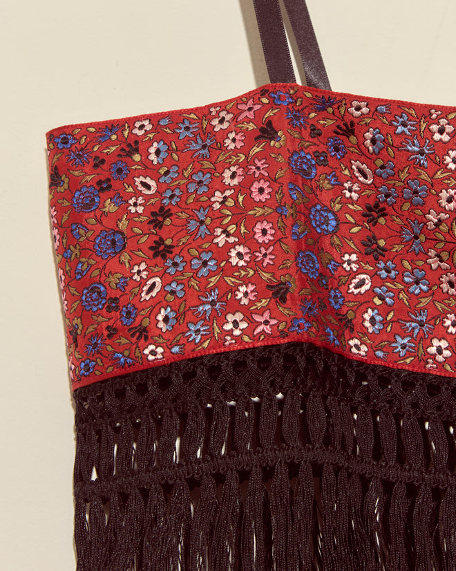 The Cloister Garden Bra - S features a unique red floral fabric, black straps, and antique piano shawl fringe, inspired by vintage brocade styles for an elegant and distinctive look.