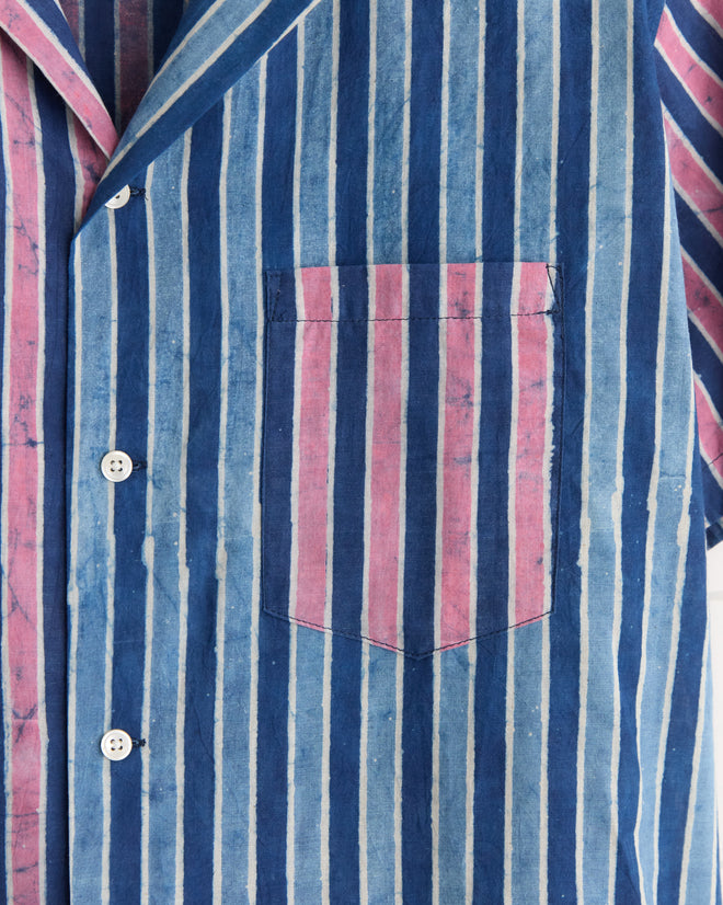The Cobalt Coral Stripe Shirt - L/XL features blue and pink stripes, white buttons, and a front pocket with vertical stripes, all crafted from deadstock fabric for a unique look.