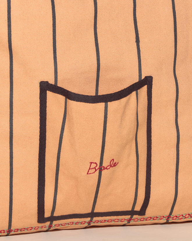 Peach fabric with thin black stripes, a pocket featuring red 