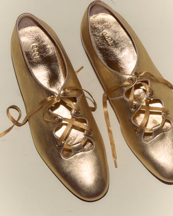 The County Clare Shoes - Metallic are shiny gold lace-up shoes made from metallic-treated leather with ribbon laces, shown from above on a light background.