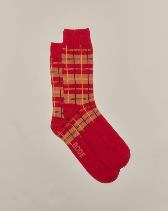 County Plaid Socks - Red Multi feature a red plaid pattern with "BODE" on the sole, crafted from merino cashmere in Italy and displayed against a plain background.