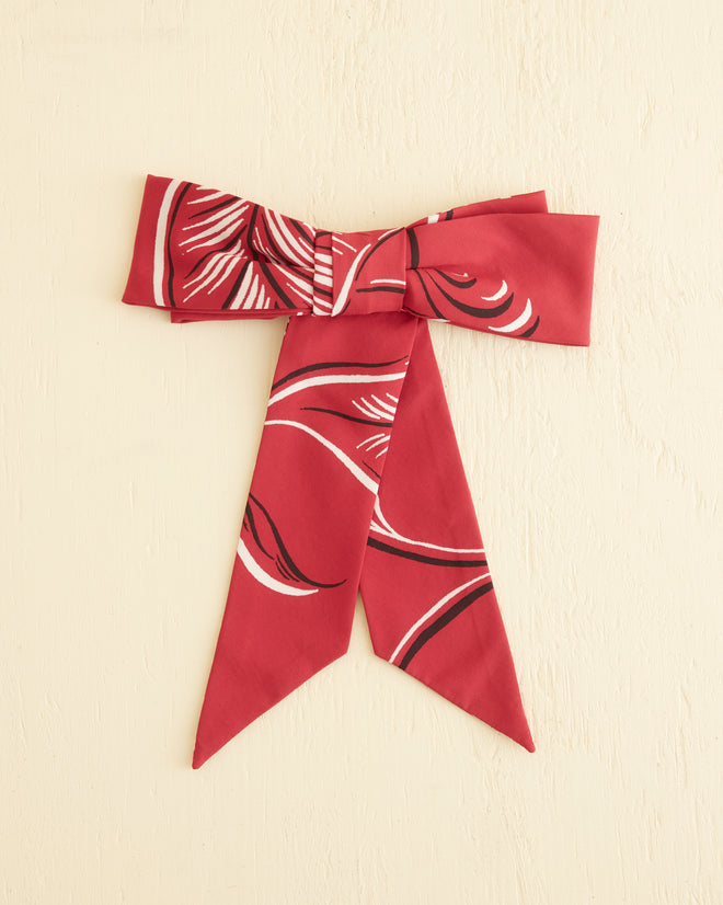 Introducing the Creeping Begonia Bow Barrette: a stunning accessory that showcases a striking red and white pattern on a light textured background. Carefully crafted as part of our viscose accessories line, it features a touch of midcentury botanical pattern for an extra dash of charm.