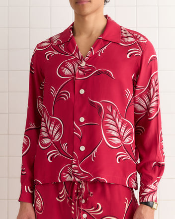 Person wearing Creeping Begonia Pajama Pants, standing by a tiled wall.