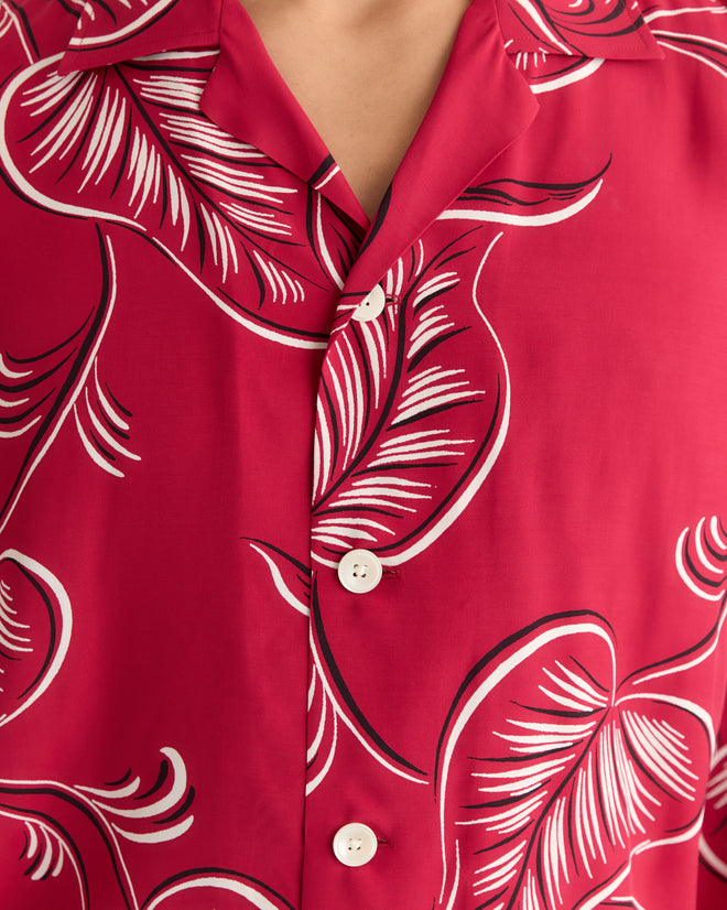 Close-up of the Creeping Begonia Short Sleeve Shirt, a red button-up featuring a white and black botanical print, crafted from 100% viscose deadstock yardage.