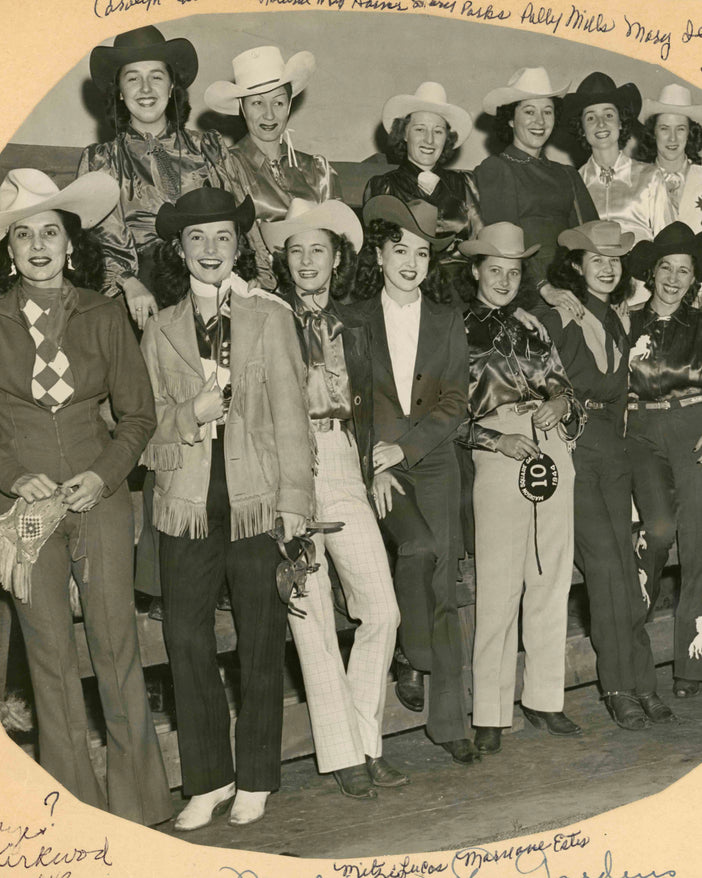 Historic photo of a group of female competitors following a rodeo.