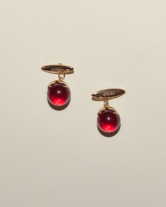 Curio Cufflinks - Red: A pair of gold Victorian Revival cufflinks featuring round, deep red gemstones set against a light background.