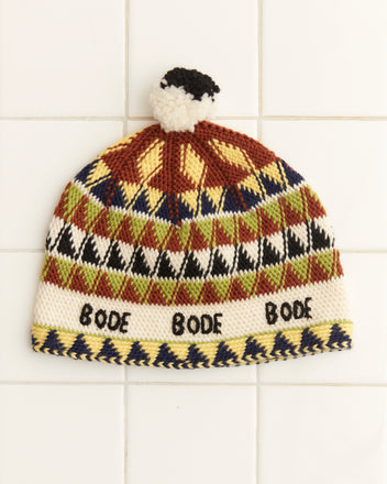 The Delta Jacquard Hat is a vibrant, handmade knit cap showcasing geometric patterns and 