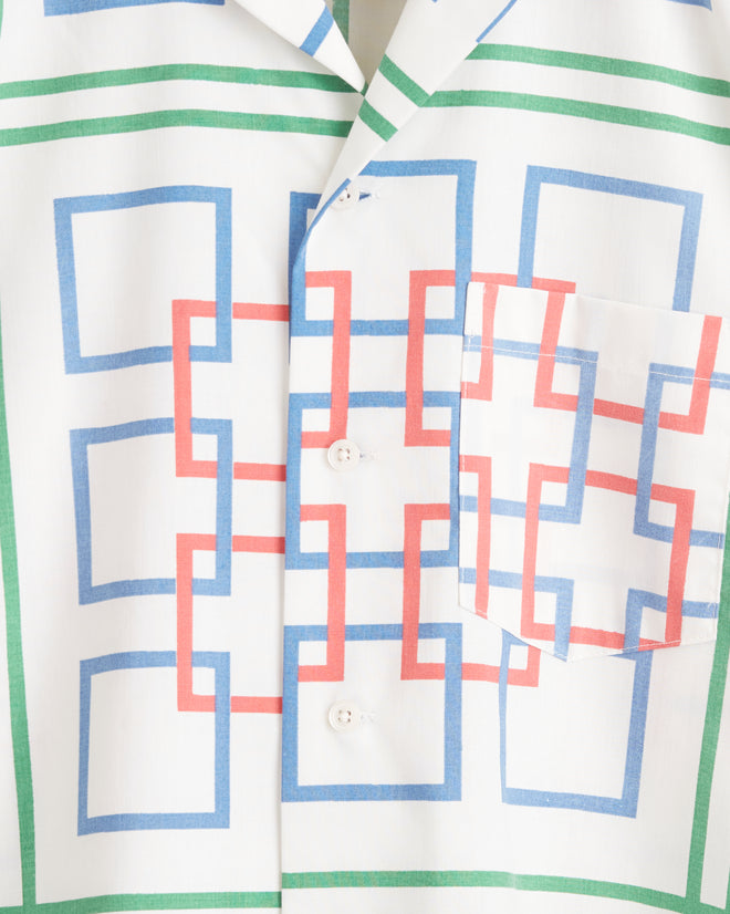 A close-up of the Dessau Maze Shirt - XS/S showcasing a colorful geometric pattern with red, blue, and green squares overlapping on a white background. This one-of-a-kind piece features buttons and a front pocket.