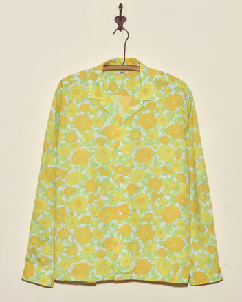 Dhalia Lime Long Sleeve Shirt (XL/XXL) with yellow and green floral pattern, button-up style, hangs on a hook against a beige wall.