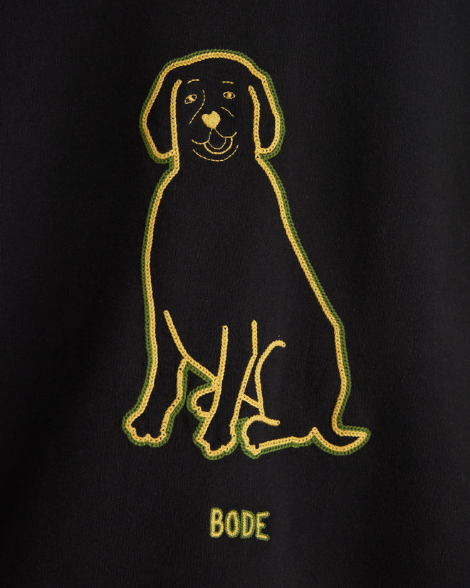 The Embroidered Dog Crewneck, a black 100% cotton sweatshirt featuring a yellow chain-stitch embroidered outline of a dog and the word 