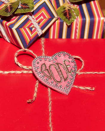 A red gift with twine and a pink heart 