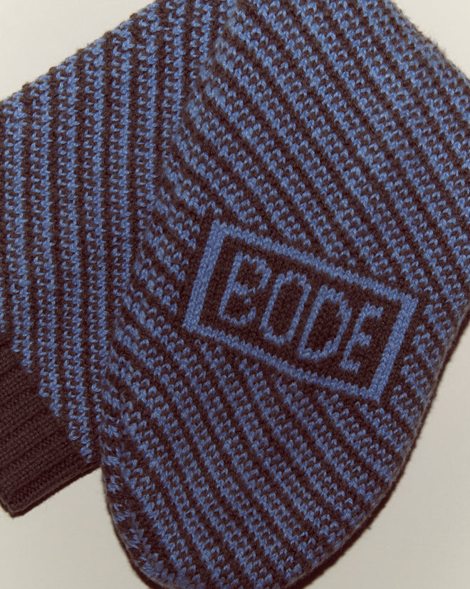 Two Duotone Jacquard Socks in blue grey, featuring knitted stripes and "BODE" stitched on one sock, inspired by historical reproduction socks.