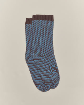 A pair of Duotone Jacquard Socks - Blue Grey, featuring blue and brown stripes, birdseye jacquard pattern, and 