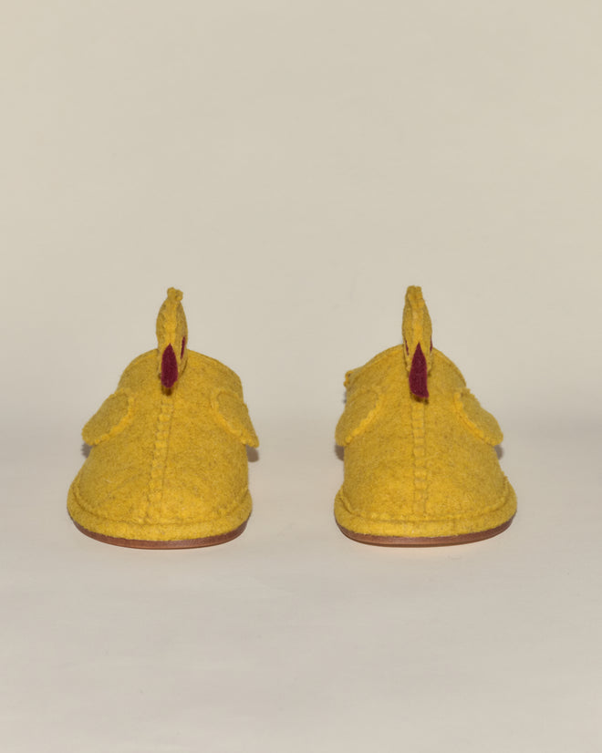 A pair of yellow Duck Slippers with fleece lining, featuring a chicken-like design, shown from the back against a plain background.