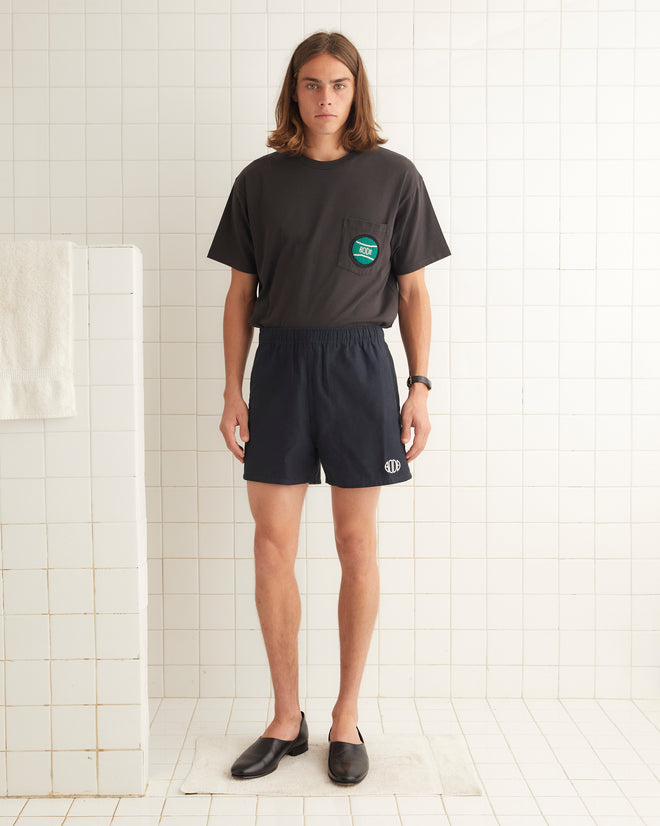 Navy cotton rugby shorts with short inseam and wide leg opening. The shorts are embroidered with a Bode logo.