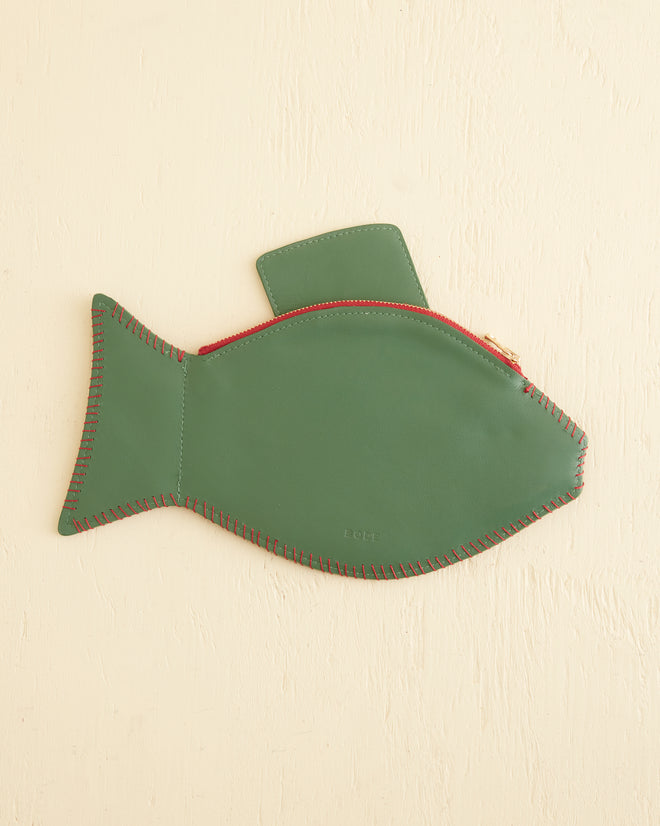 A stylish Fish Clutch, made of green leather with red stitching and details, is beautifully displayed on a beige background.