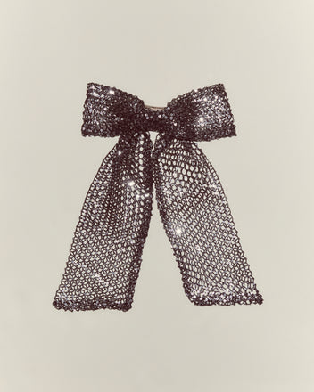 The Tanglenet Bow Barrette features sparkling silver sequins and long tails, inspired by 1930s style, displayed against a plain light background.
