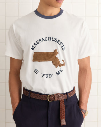 Someone wearing the Fur Me Tee, a 100% cotton white souvenir shirt featuring "Massachusetts is 'fur' me" and a furry state outline design.