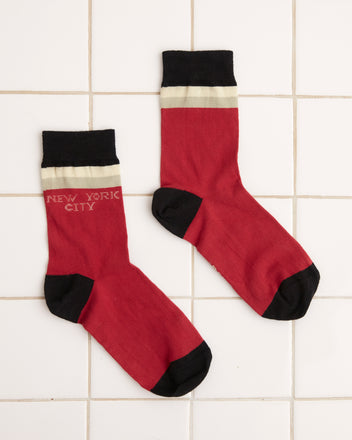 A pair of Fairground Socks - Red, boasting black toes and heels and adorned with 