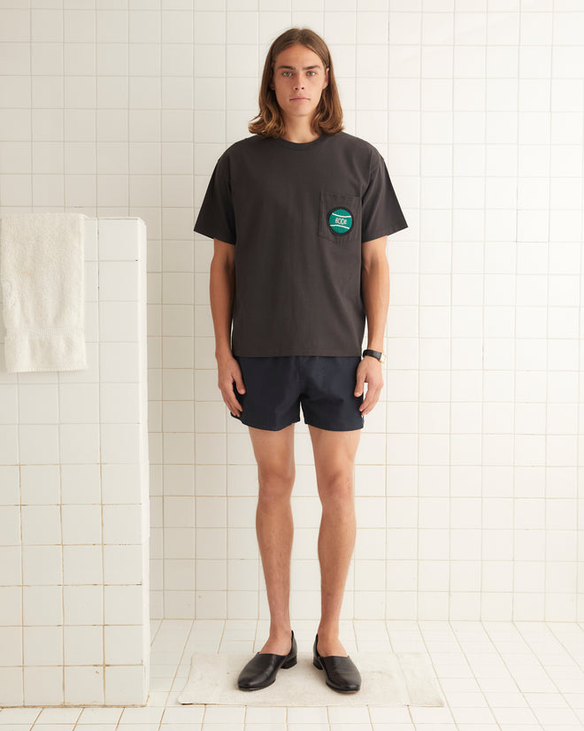 Washed cotton short sleeve tee with small tennis ball beaded on left breast pocket.