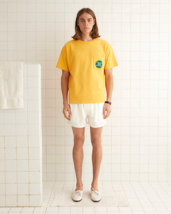 Washed cotton short sleeve tee with small tennis ball beaded on left breast pocket.