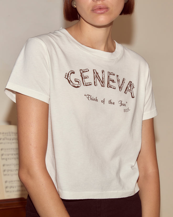 Someone wears a white Geneva Tee featuring "Think of the Fun" text, captured indoors—reminiscent of a moment from a vintage photo album.