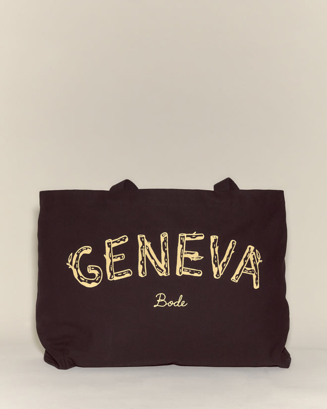 The Geneva Tote is a black canvas bag featuring "GENEVA" and "Bode" in yellow on the front—ideal for carrying essentials to Camp Geneva.