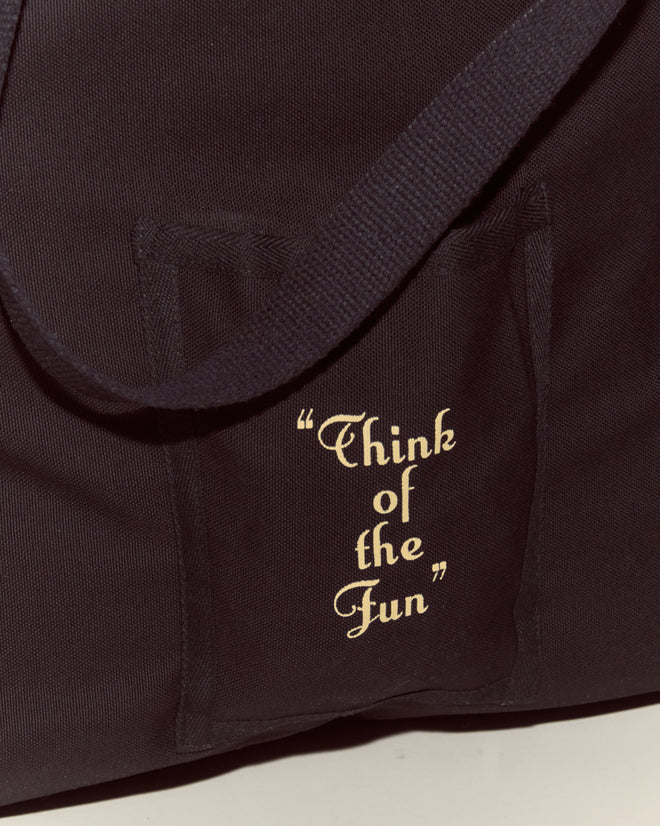 The Geneva Tote is a black cotton canvas bag with "Think of the Fun" in light script on the front pocket—ideal for summer days at Camp Geneva.