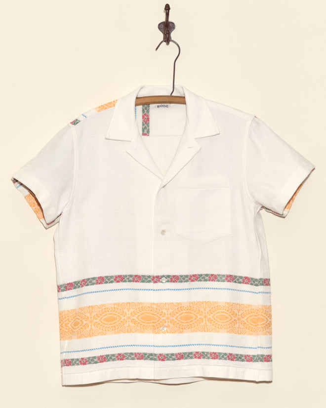 Geography Stripe Short Sleeve Shirt - XS: Handmade white button-up with orange and pink patterned stripes, displayed hanging on a hook.