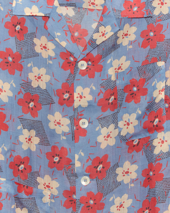 Close-up of the Geo Poppy Long Sleeve Shirt, inspired by 1940s style, in cornflower blue with a red and white floral pattern, white buttons, and a chest pocket.
