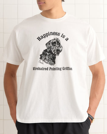 Man wears the Happiness Tee, a 100% cotton vintage-style shirt with a dog sketch and the text: 