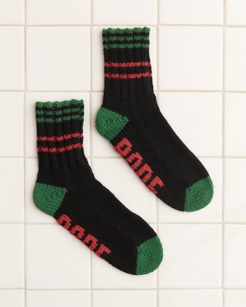 Hawthorne Stripe Socks, black knitted and crafted from merino wool, showcase green heels and stripes with red embroidered numbers 