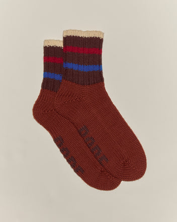 A pair of Herrington Stripe Socks - Brown, featuring chunky knit and red, blue, and beige stripes near the cuffs, displayed on a light background.
